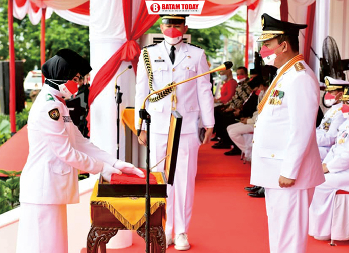 Gubernur Ansar saat memberikan bendera merah putih kepada petugas upacara